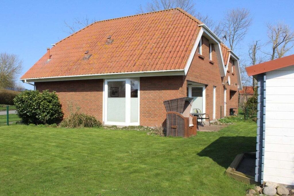 A brick house with a sloped roof, a front door, and a small porch area.