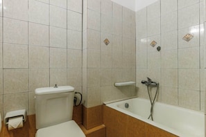 A bathroom with a toilet, a bidet, and a bathtub.