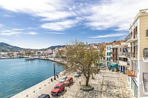 A coastal town with a marina, parked cars, and buildings along the waterfront.