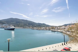 A coastal town with a marina, a large cruise ship, and a clear sky.