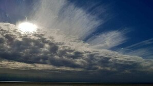 A beach with a cloudy sky and sunlight breaking through. - "Pirates" in the Boatswain's House (Nebel)