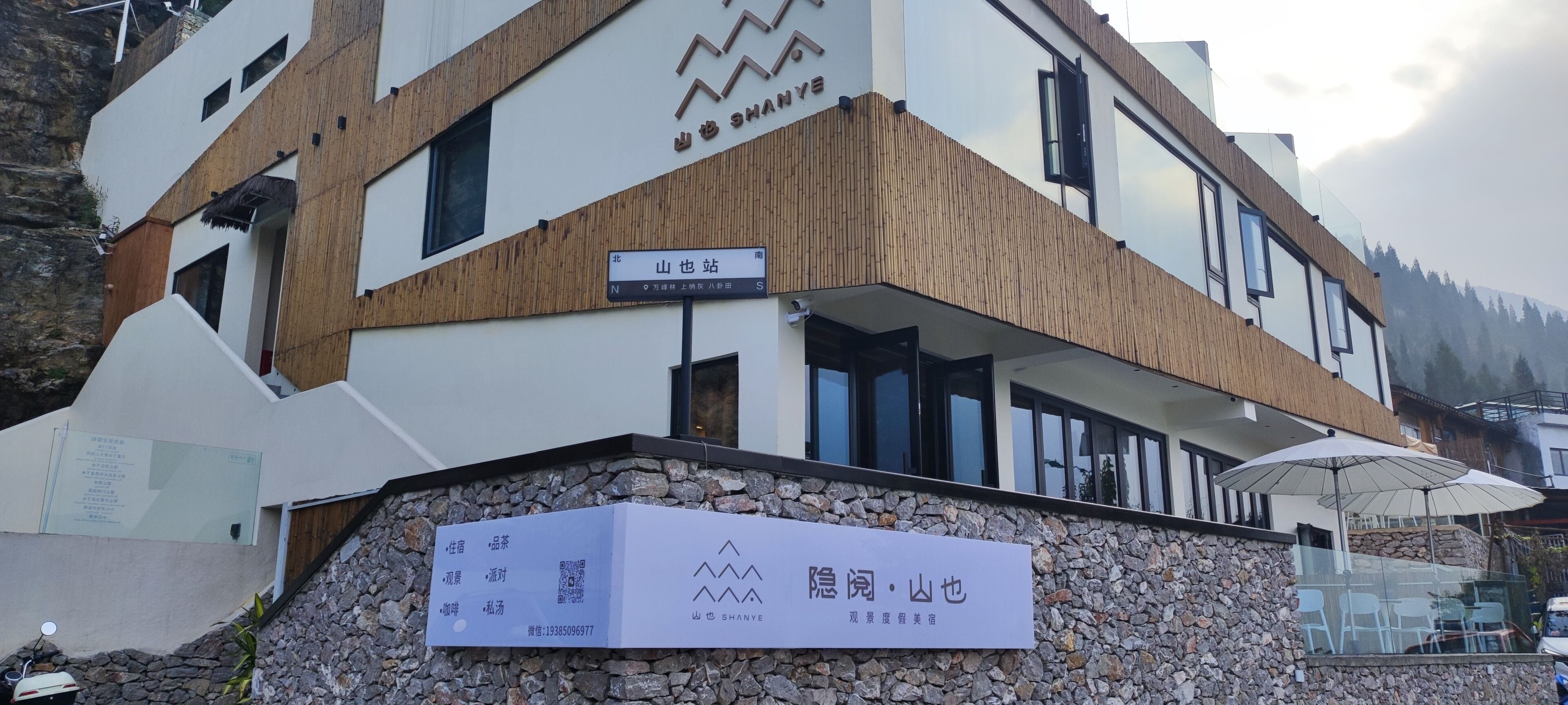 A modern building with a sign indicating a location.