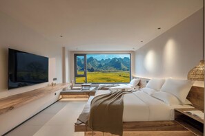 A modern bedroom with a large bed, a TV, and a view of a mountainous landscape.