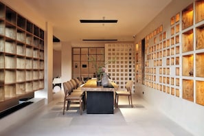A modern dining area with a long table, chairs, and a decorative vase.