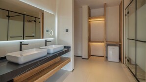 Un baño moderno con dos lavamanos, un espejo grande y una ducha a ras de suelo.