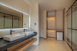Un baño moderno con dos lavamanos, un espejo grande y una ducha a ras de suelo.
