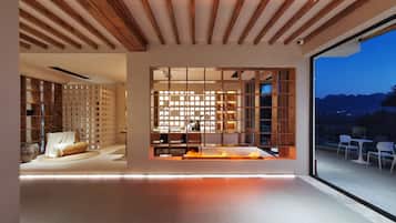 Un intérieur moderne avec un plafond en bois, une cheminée et une vue sur l’extérieur.