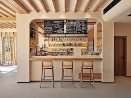 Un área de bar con techo de madera, un menú en pizarra y taburetes.