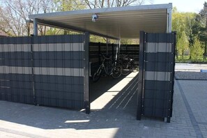 A covered bicycle parking area with a gated entrance. - Holiday apartment with 1 bedroom (Grömitz)