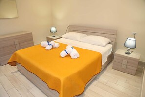 Une chambre d’hôtel avec un lit, deux tables de chevet et une lampe sur chaque table.