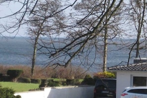 A residential area with a house, a driveway, and a parked car. - Holiday apartment with 1 bedroom (Schönhagen)