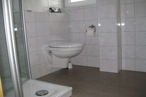 Un bagno con un water, una cabina doccia e un lavandino.