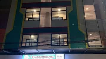 A multi-story building with a laundry facility on the ground floor, featuring a brightly colored exterior and multiple windows.