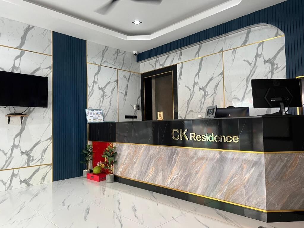 A reception desk with a marble finish and the name 'CK Residence' on it.