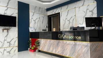 A reception desk with a marble finish and the name 'CK Residence' on it.