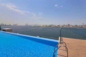 A swimming pool with a city skyline in the background. - Exquisite 1 Bed l Creek Skyline View l Gym & Pool (Dubai)