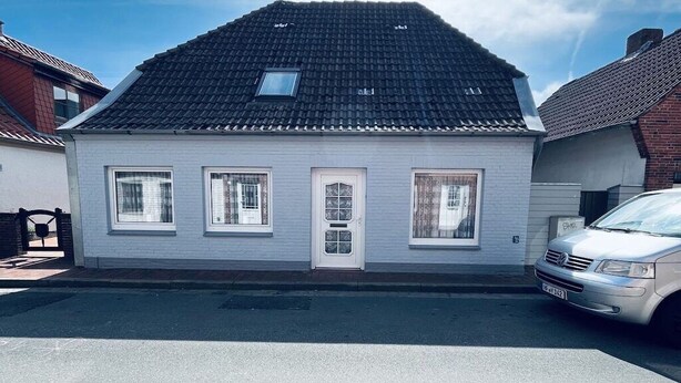 A two-story house with a tiled roof, a front door, and three windows. - Holiday apartment with 1 bedroom (Tönning)