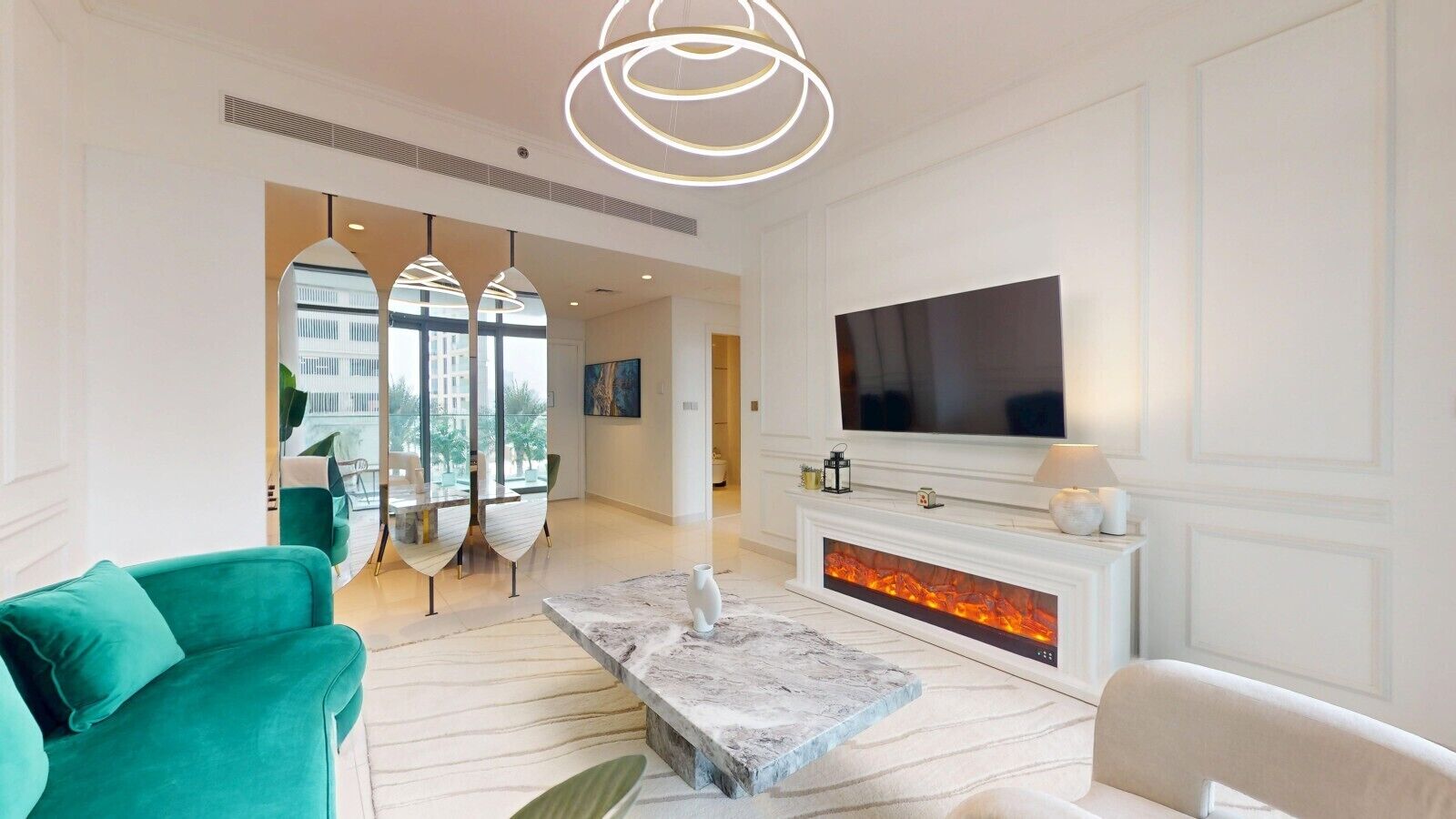 A modern living room with a fireplace, a flat-screen TV, and a green sofa.