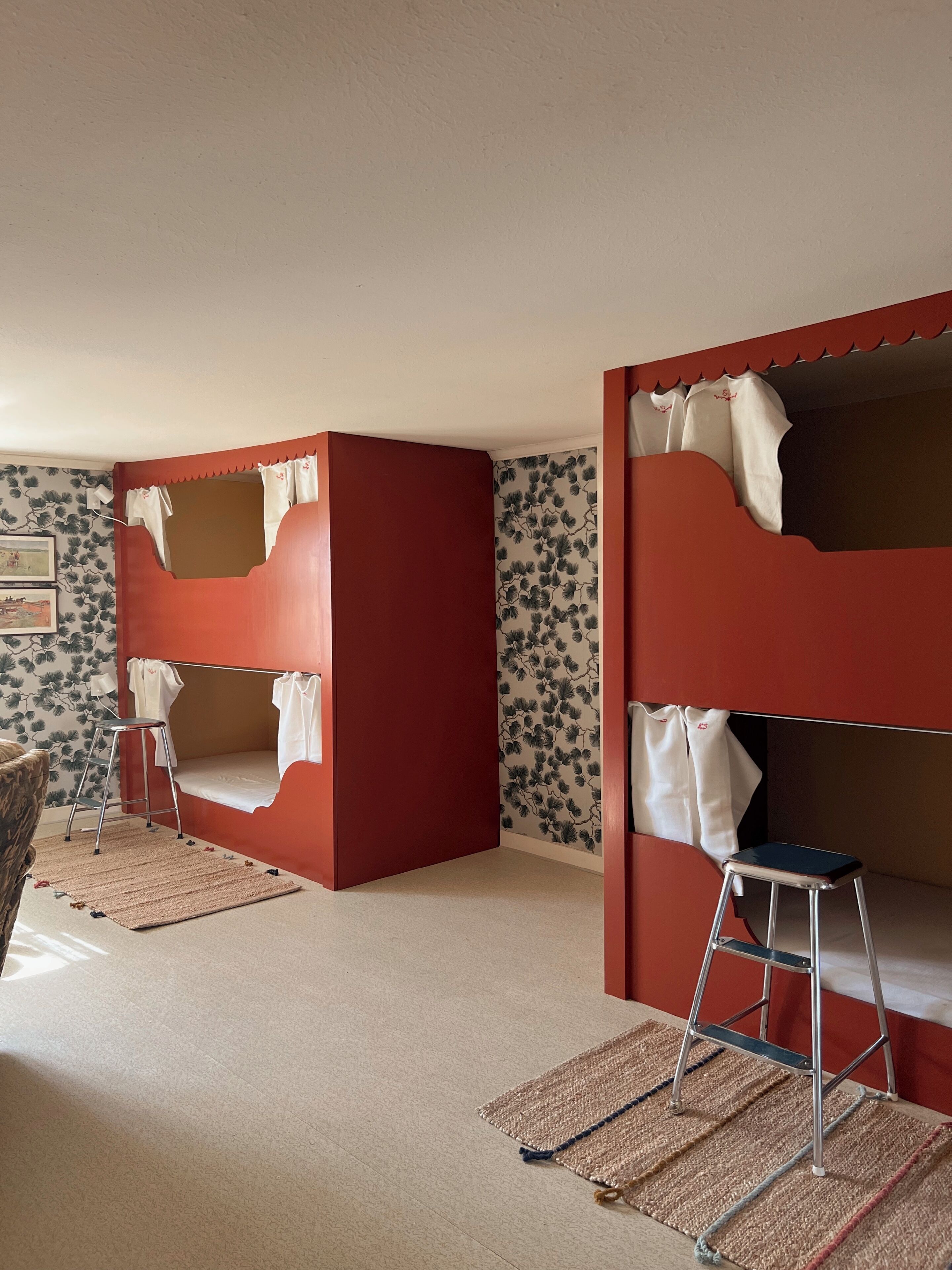 Una habitació amb llits superposats, una escala i una catifes amb motius.