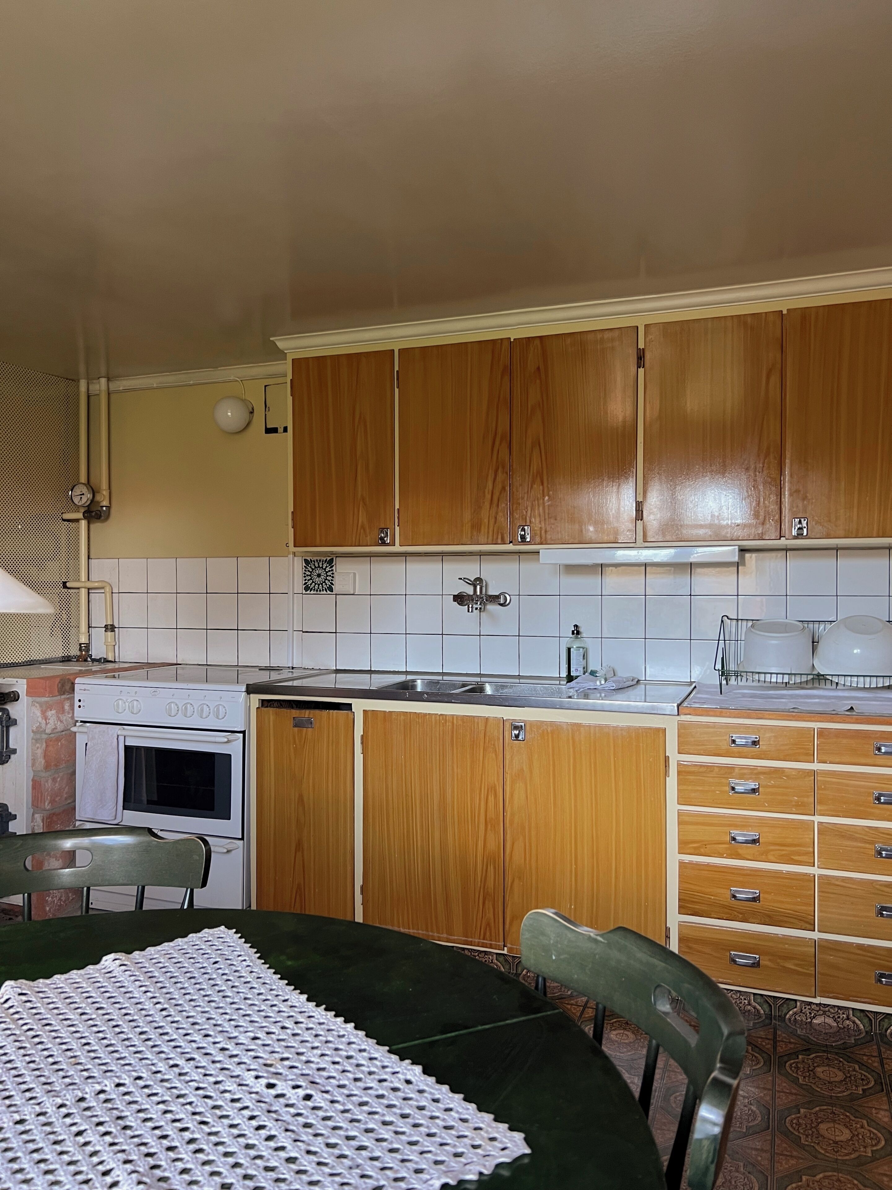 A kitchen with wooden cabinets, a stove, and a sink.