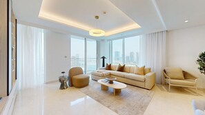A modern living room with a sofa, two armchairs, a coffee table, and a city view through large windows. - Upgraded 2 Bed l Beach View l Emaar Beachfront (Emaar Beachfront)