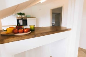 Una encimera de cocina con un plato de verduras y una vela.