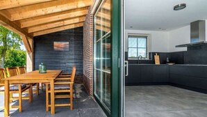 Cozinha moderna com bancada preta e eletrodomésticos de aço inoxidável.