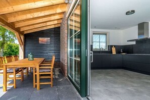 Een moderne keuken met een zwart aanrecht en roestvrijstalen apparatuur.