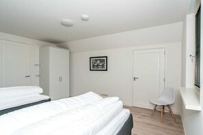 Een slaapkamer met twee bedden, een bureau en een stoel.