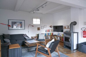 A living room with a sofa, armchairs, a coffee table, a fireplace, a television, and a bookshelf. - ||-------------------at Schlabornsee-------------------|| (Zechlinerhütte)