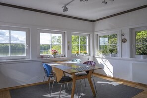 A room with a table and chairs, large windows, and a view of greenery outside. - ||-------------------at Schlabornsee-------------------|| (Zechlinerhütte)