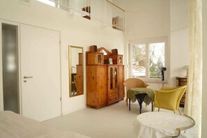 A room with a bed, a wooden cabinet, a chair, and a table. - Holiday apartment with 6 bedrooms (Starnberg)