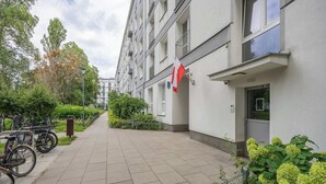 A residential building with a flag, bicycles, and greenery.