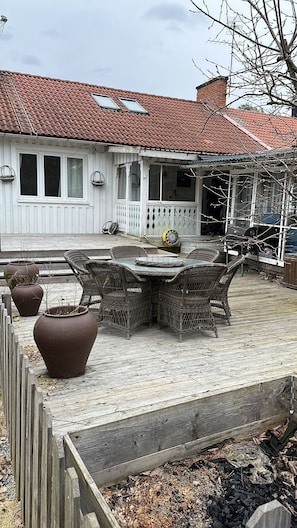 A patio with a round table and chairs, surrounded by potted plants.