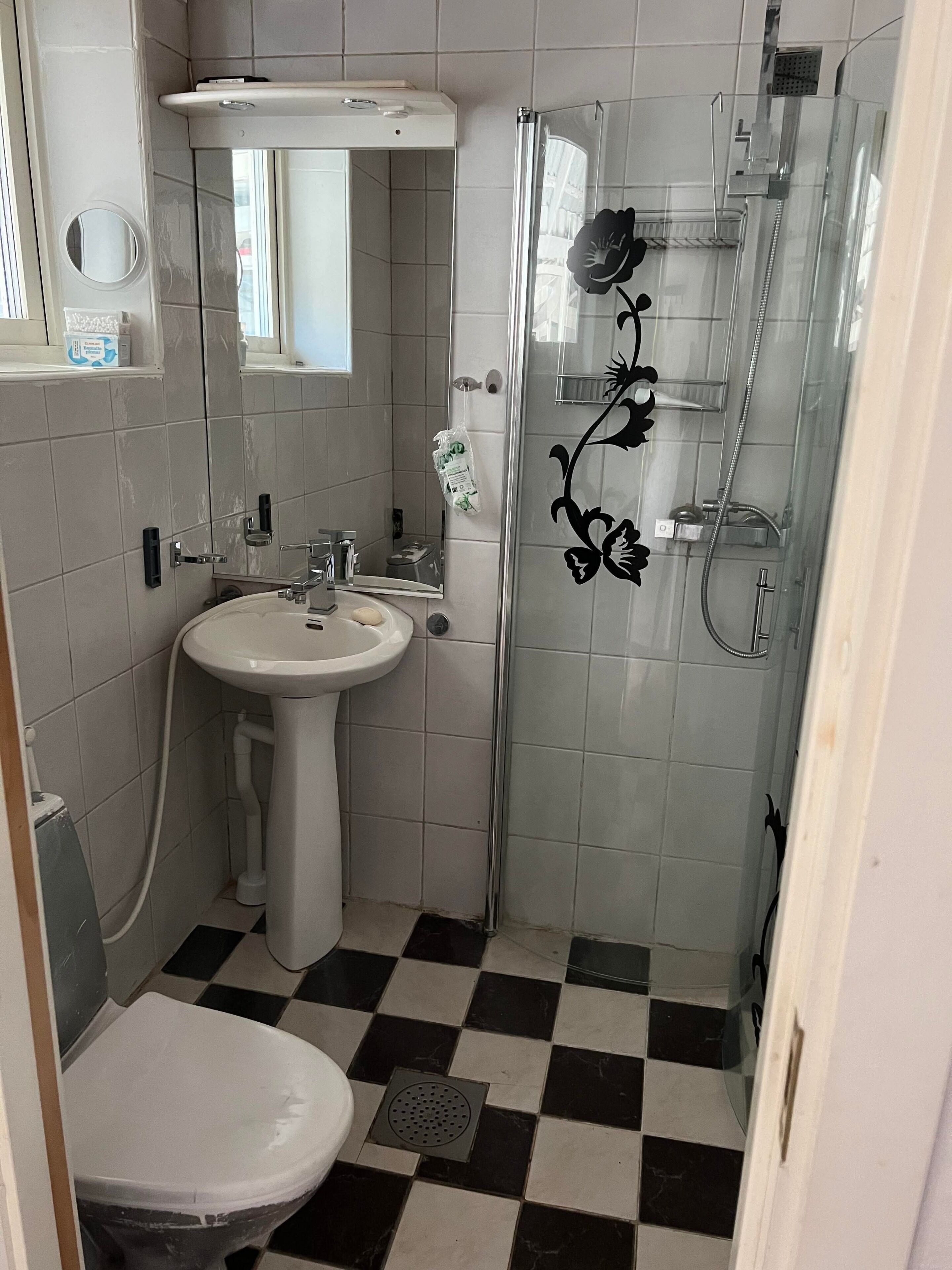 Kylpyhuone, jossa on pesuallas, peili, wc ja suihkutila.
