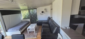 A compact living space with a sofa, a small table, and a bed.