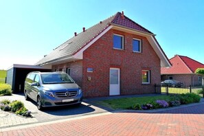 Een rijtjeshuis met een auto op de oprit.