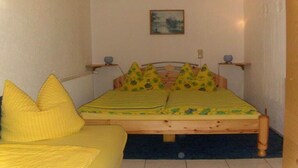 A room with a bed, a sofa, and a painting on the wall. - Holidays at Bärbel Güldner's (Feldberger Seenlandschaft)