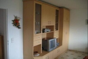 A room with a wooden cabinet, a television, and a small table. - Holiday apartment with 1 bedroom (Meersburg)