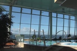 An indoor swimming pool with clear views of the ocean through large windows. - Holiday apartment with 1 bedroom (Meersburg)