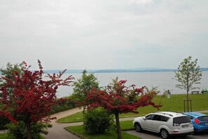 A parking area with a view of a lake and distant mountains. - Holiday apartment with 1 bedroom (Meersburg)