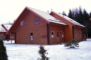 A wooden cabin with a pitched roof, multiple windows, and a snow-covered ground. - Hasselfelde House 32 (Hasselfelde)