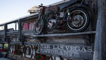A motorcycle on a wooden structure with a sign that reads 'BAR LAS VEGAS RESTORANTE'.