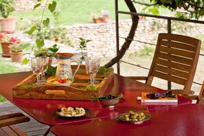 A table set outdoors with a wooden tray, glasses, a pitcher, and a book. - Holiday home in Bonnieux with swimming pool (Bonnieux)