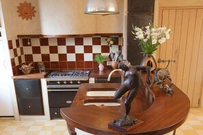 A kitchen with a checkered backsplash, a stove, a sink, and a decorative sculpture on the counter. - Holiday home in Bonnieux with swimming pool (Bonnieux)