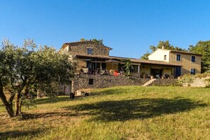 A two-story house with a stone facade, a balcony, and a grassy yard. - Holiday home in Bonnieux with swimming pool (Bonnieux)