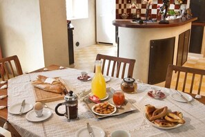 A breakfast setting with a table set for two, including bread, pastries, a coffee pot, and a juice pitcher. - Holiday home in Bonnieux with swimming pool (Bonnieux)