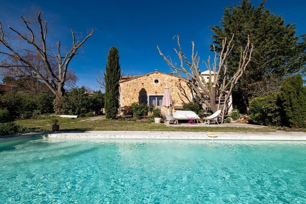 A stone building with a pool, a hammock, and a clear blue sky.