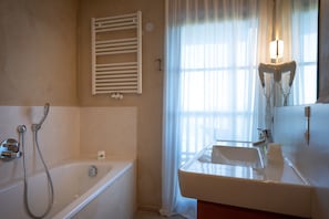 A bathroom with a bathtub, a shower, a sink, and a mirror. - Room 6 with Mountain View (Badia)