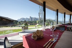 A dining table set with cutlery and glasses, overlooking a mountainous landscape. - Room 6 with Mountain View (Badia)